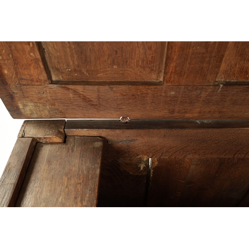 444 - A 17TH CENTURY CARVED OAK LINEN FOLD COFFER with four panel top and iron lock plate; raised on stile... 