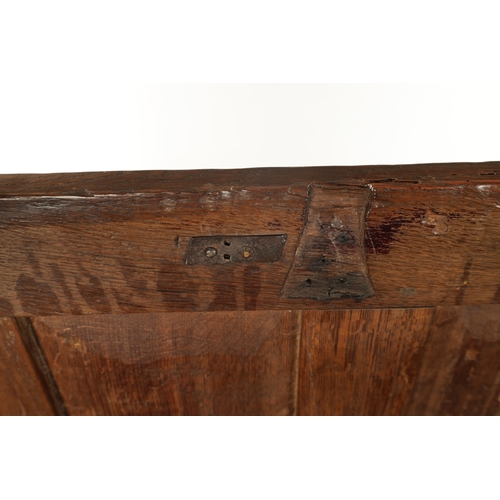 444 - A 17TH CENTURY CARVED OAK LINEN FOLD COFFER with four panel top and iron lock plate; raised on stile... 