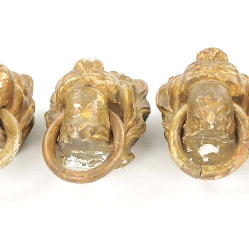 46 - A SET OF FOUR REGENCY CARVED GILTWOOD LION'S HEADS three with looped handles. (10.5cm wide)