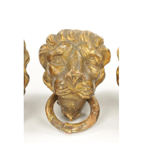 46 - A SET OF FOUR REGENCY CARVED GILTWOOD LION'S HEADS three with looped handles. (10.5cm wide)