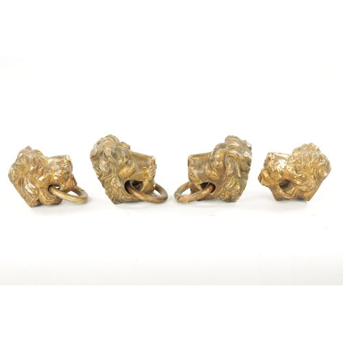 46 - A SET OF FOUR REGENCY CARVED GILTWOOD LION'S HEADS three with looped handles. (10.5cm wide)