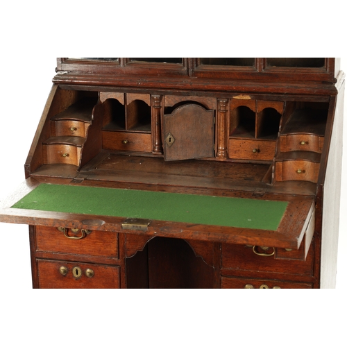 5 - AN UNUSUAL QUEEN ANNE OAK KNEEHOLE BUREAU BOOKCASE with glazed top section above an angled fall with... 