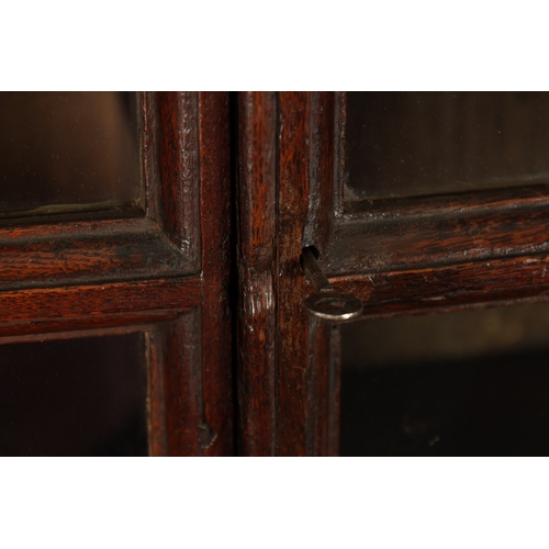 5 - AN UNUSUAL QUEEN ANNE OAK KNEEHOLE BUREAU BOOKCASE with glazed top section above an angled fall with... 