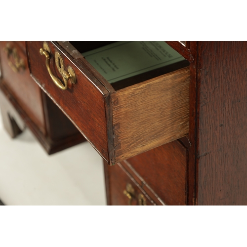 5 - AN UNUSUAL QUEEN ANNE OAK KNEEHOLE BUREAU BOOKCASE with glazed top section above an angled fall with... 