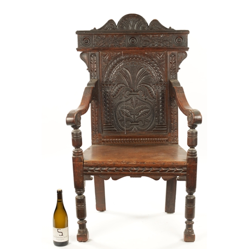 55 - A 17TH CENTURY CARVED OAK WAINSCOT CHAIR having leaf carved back and plank seat; open arms and turne... 