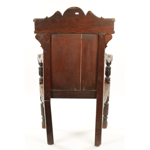 55 - A 17TH CENTURY CARVED OAK WAINSCOT CHAIR having leaf carved back and plank seat; open arms and turne... 