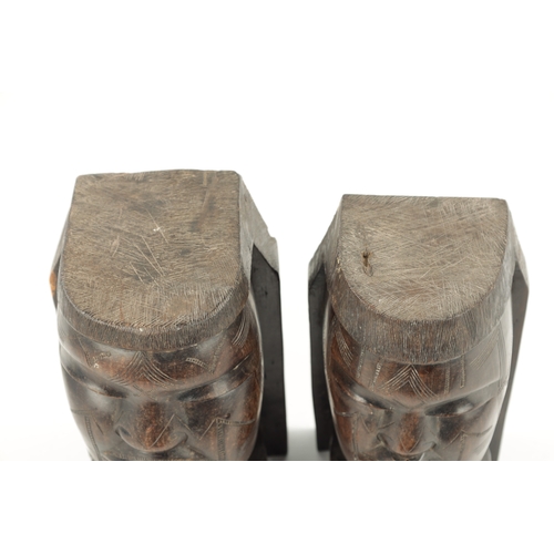 82 - A PAIR OF CARVED HARDWOOD NATIVE BOOKENDS formed as Heads. (22cm high)