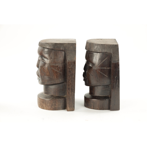 82 - A PAIR OF CARVED HARDWOOD NATIVE BOOKENDS formed as Heads. (22cm high)