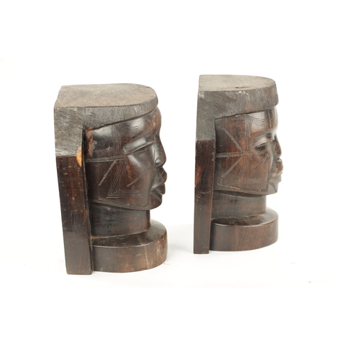 82 - A PAIR OF CARVED HARDWOOD NATIVE BOOKENDS formed as Heads. (22cm high)