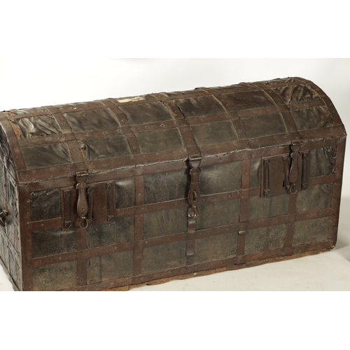 86 - A RARE 17TH CENTURY DOMED TOP IRON BOUND LEATHER COVERED COFFER with side handles and triple lock fr... 