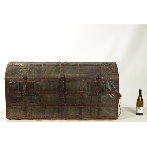 86 - A RARE 17TH CENTURY DOMED TOP IRON BOUND LEATHER COVERED COFFER with side handles and triple lock fr... 