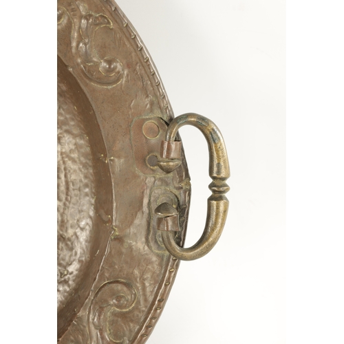 94 - AN EARLY 18TH CENTURY SPANISH EMBOSSED BRASS TWO HANDLED DISH with figural centre (50.5cm diameter)