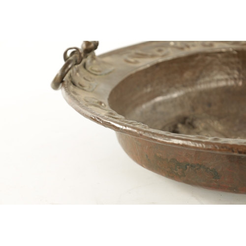 94 - AN EARLY 18TH CENTURY SPANISH EMBOSSED BRASS TWO HANDLED DISH with figural centre (50.5cm diameter)