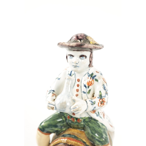 465 - AN 18TH / 19TH CENTURY DELFT POLYCHROME FIGURE modelled as a man sitting on a barrel drinking out of... 