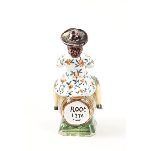 465 - AN 18TH / 19TH CENTURY DELFT POLYCHROME FIGURE modelled as a man sitting on a barrel drinking out of... 