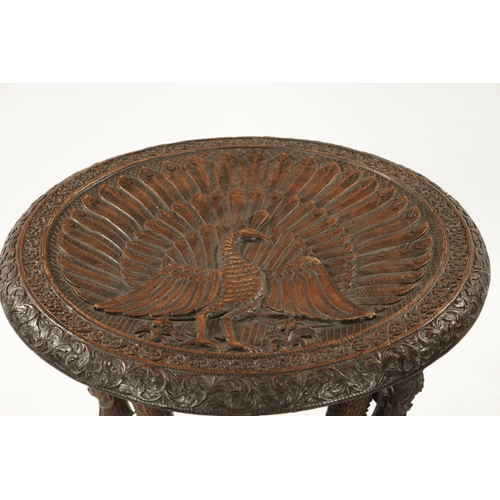 496 - A 19TH CENTURY INDIAN HARDWOOD OCCASIONAL TABLE the circular top with carved scrollwork border enclo... 