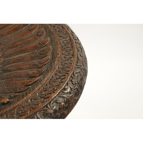 496 - A 19TH CENTURY INDIAN HARDWOOD OCCASIONAL TABLE the circular top with carved scrollwork border enclo... 