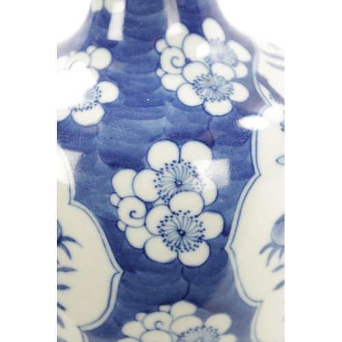 517 - A 19TH CENTURY CHINESE BLUE AND WHITE BOTTLENECK VASE with prunus pattern ground and floral panels. ... 