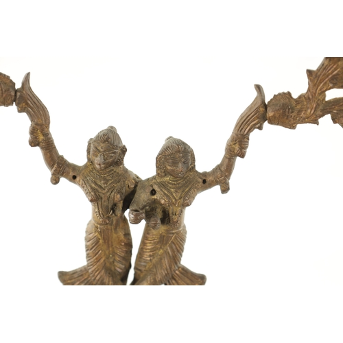 528 - A PAIR OF 19TH CENTURY GILT BRASS INDIAN CANDELABRA with figures standing on the backs of a horse an... 