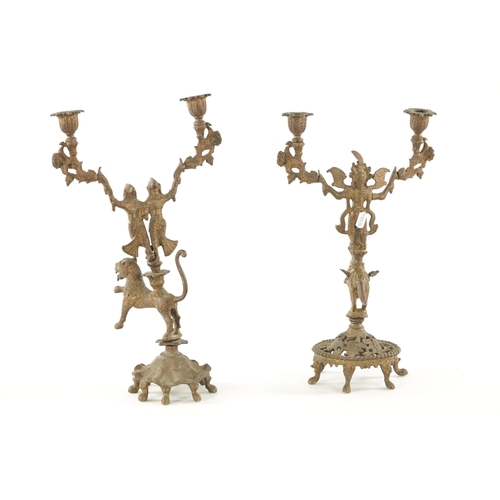 528 - A PAIR OF 19TH CENTURY GILT BRASS INDIAN CANDELABRA with figures standing on the backs of a horse an... 