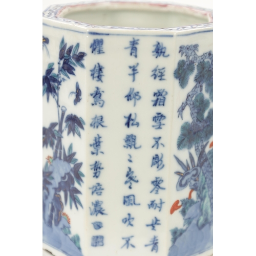 545 - A CHINESE QING DYNASTY BLUE AND WHITE OCTAGONAL SHAPED BRUSH POT with script and blossoming trees to... 