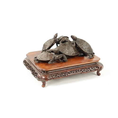 572 - A FINE JAPANESE MEIJI PERIOD BRONZE SCULPTURE OF A GROUP OF TURTLES mounted on a pierced carved hard... 