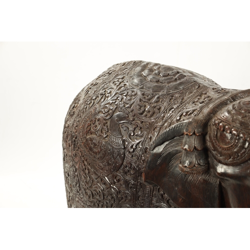 576 - A LARGE EARLY 20TH CENTURY CARVED HARDWOOD ELEPHANT finely carved with scrollwork foliage and stylis... 