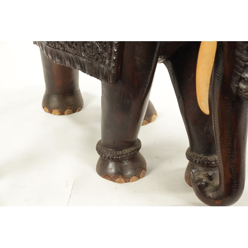 576 - A LARGE EARLY 20TH CENTURY CARVED HARDWOOD ELEPHANT finely carved with scrollwork foliage and stylis... 