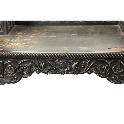 593 - A 19TH CENTURY CARVED COROMANDEL INDO-PORTUGUESE WRITING DESK of serpentine shape with leaf-carved d... 