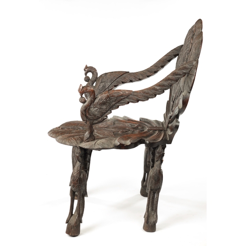 594 - A 19TH CENTURY ANGLO-INDIAN CARVED HARDWOOD ARMCHAIR decorated with flamingo and serpent panels on a... 