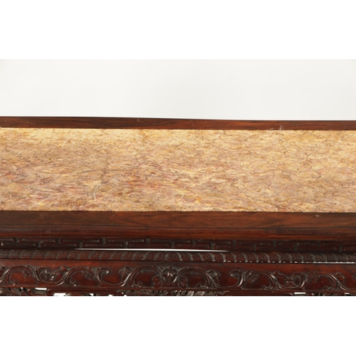 598 - A 19TH CENTURY CHINESE HARDWOOD ALTER TABLE with inset marble top above peirced carved leafwork base... 