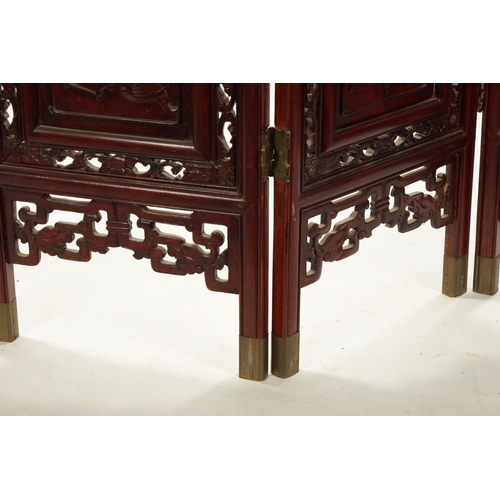 599 - AN EARLY 20TH CENTURY CHINESE FOUR-SECTION FOLDING SCREEN having pierced carved hardwood frames encl... 