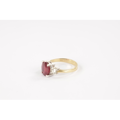 620 - AN 18CT GOLD RUBY AND DIAMOND RING having an oval cut ruby flanked by two brilliant cut diamonds all... 