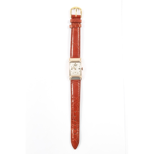 630 - A 1940’S ROLLED GOLD BULOVA MASONIC WRISTWATCH on brown alligator leather strap, the slightly curved... 