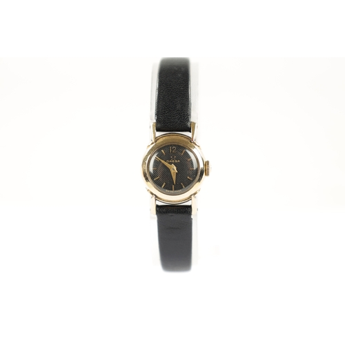 640 - A LADIES OMEGA WRISTWATCH on black leather strap, the rolled gold case enclosing an unusual black ho... 