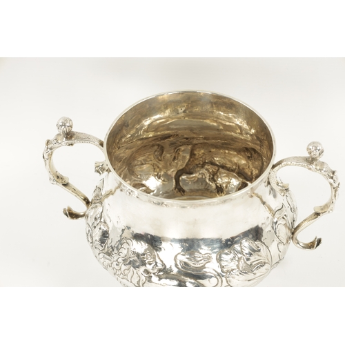 669 - A FINE CHARLES II OVERSIZED SILVER PORRINGER of bellied form embossed with a continuous band of leaf... 