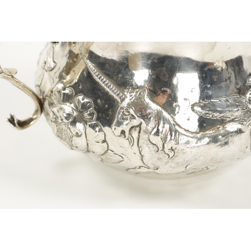 669 - A FINE CHARLES II OVERSIZED SILVER PORRINGER of bellied form embossed with a continuous band of leaf... 