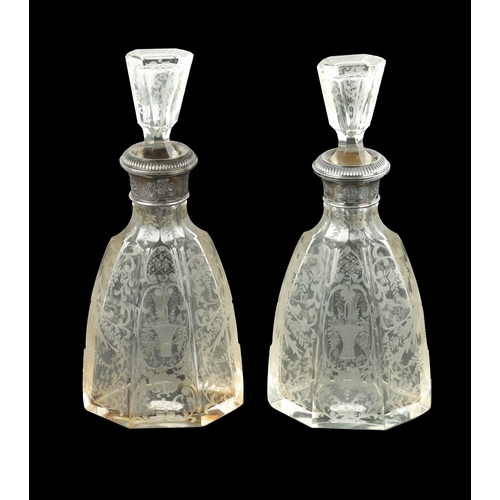 677 - A NEAR PAIR OF 19TH CENTURY SILVER TOPPED CUT GLASS DECANTERS of facetted form with embossed contine... 