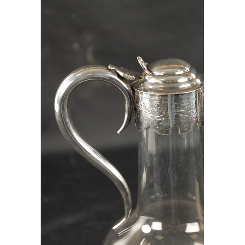 688 - A VICTORIAN SILVER MOUNTED GLASS CLARET JUG with star-cut bulbous base and engraved mask-head silver... 