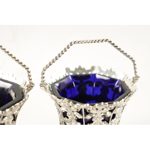 699 - A PAIR OF MID 19TH CENTURY SILVER SWEET BASKETS with rope twist handles and pierced repousse faceted... 