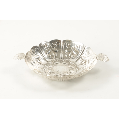 701 - A FINE WILLIAM III SILVER SWEETMEAT DISH of shallow petal shaped design with overall embossed decora... 