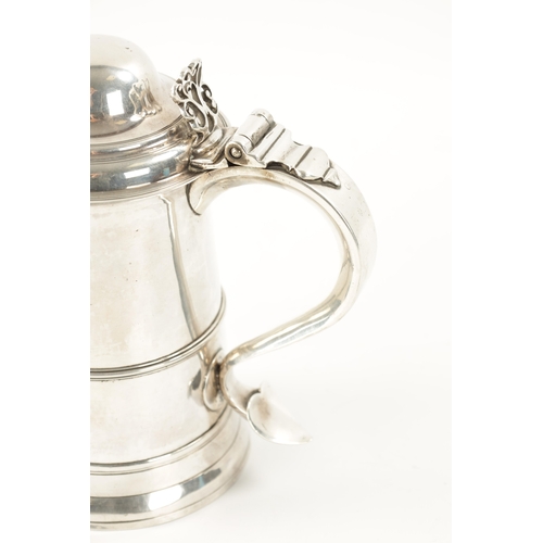 712 - A GEORGE III SILVER TANKARD of plain monogrammed tapering footed form with ribbed girdle, dome cover... 