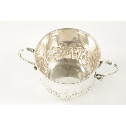 716 - A CHARLES II SILVER PORRINGER the monogrammed body with sprouting leafwork lower band and scrolled h... 