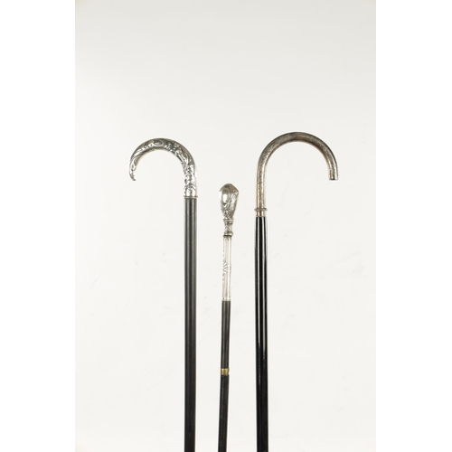 751 - A COLLECTION OF THREE ART NOUVEAU SILVER TOPPED WALKING STICKS two with hook handles, embossed and e... 