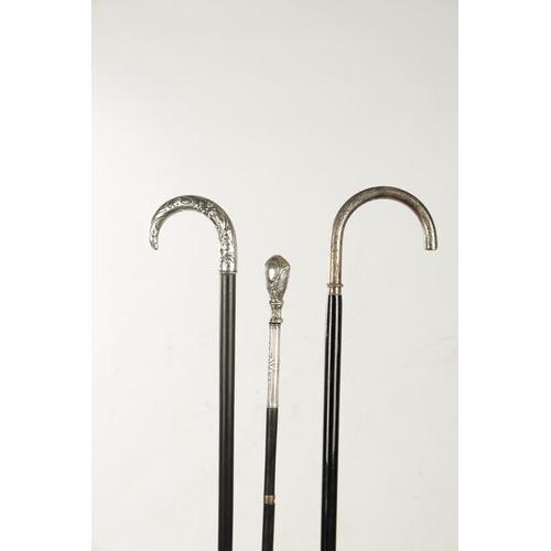 751 - A COLLECTION OF THREE ART NOUVEAU SILVER TOPPED WALKING STICKS two with hook handles, embossed and e... 