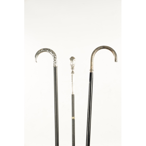 751 - A COLLECTION OF THREE ART NOUVEAU SILVER TOPPED WALKING STICKS two with hook handles, embossed and e... 