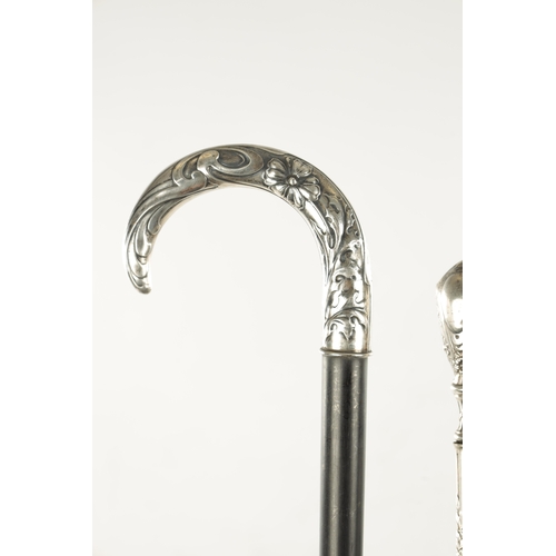 751 - A COLLECTION OF THREE ART NOUVEAU SILVER TOPPED WALKING STICKS two with hook handles, embossed and e... 