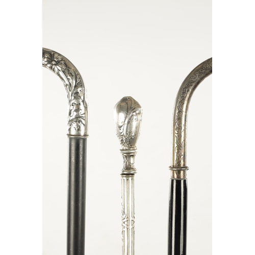 751 - A COLLECTION OF THREE ART NOUVEAU SILVER TOPPED WALKING STICKS two with hook handles, embossed and e... 