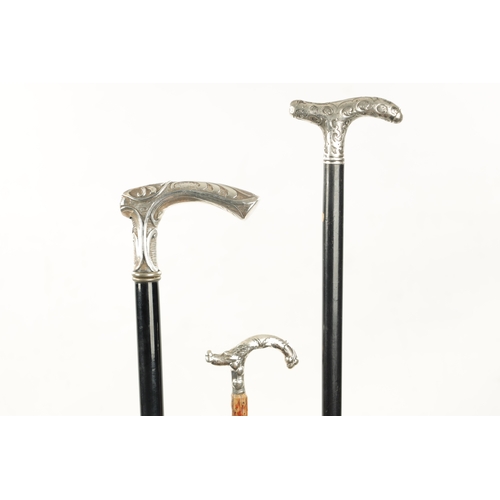 753 - A COLLECTION OF THREE LATE 19TH CENTURY ART NOUVEAU SILVER TOPPED WALKING STICKS with shaped handles... 