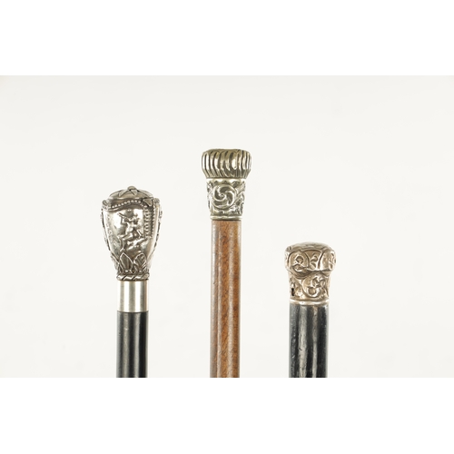 756 - A COLLECTION OF THREE LATE 19TH CENTURY SILVER TOPPED WALKING STICKS embossed with floral and classi... 